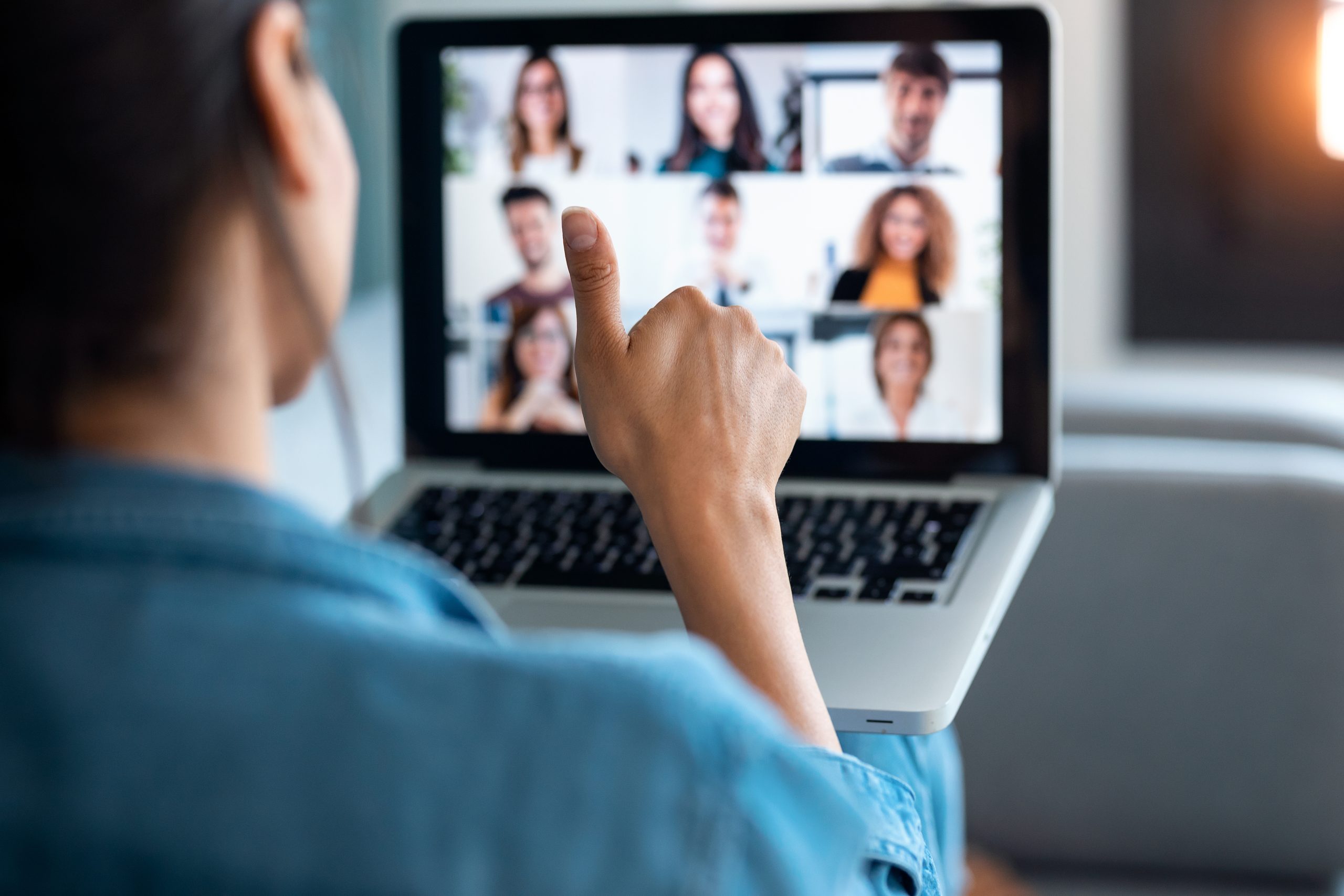 Business woman making video call and showing thumb up to laptop